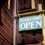 Schild weist auf einen geöffneten Boostore in englischer Sprache hin. Das Schild ist an einem alten Haus angebracht