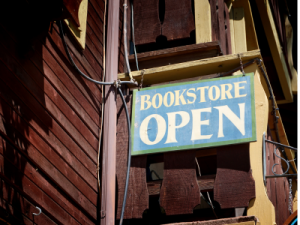 Schild weist auf einen geöffneten Boostore in englischer Sprache hin. Das Schild ist an einem alten Haus angebracht
